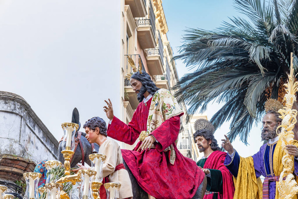 Christ riding a donkey in the Throne or platform of the Brotherhood of the La Borriquita, in procession by the narrow streets of the city - Foto, Imagem