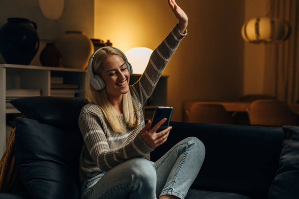Cheerful Caucasian woman is listening to music at home - Foto, immagini