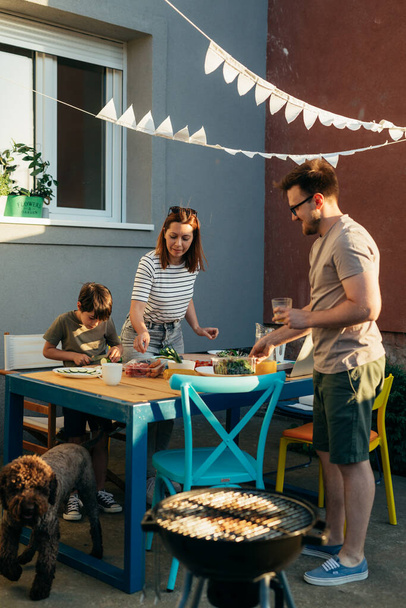 Caucasian family is preparing lunch in the backyard - Zdjęcie, obraz