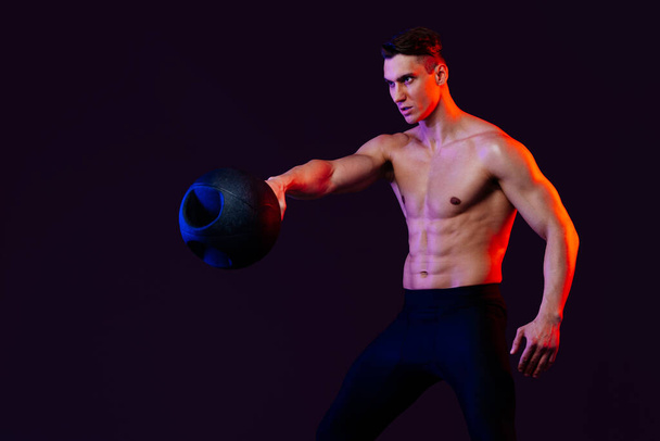 Athletic man with fit muscular body training in studio - Active man doing a workout, colorful lighting and background, concepts about fitness, sport and health lifestyle - Foto, Bild