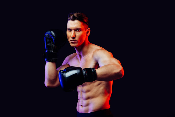 Athletic man with fit muscular body training in studio - Active man doing a workout, colorful lighting and background, concepts about fitness, sport and health lifestyle - Foto, imagen