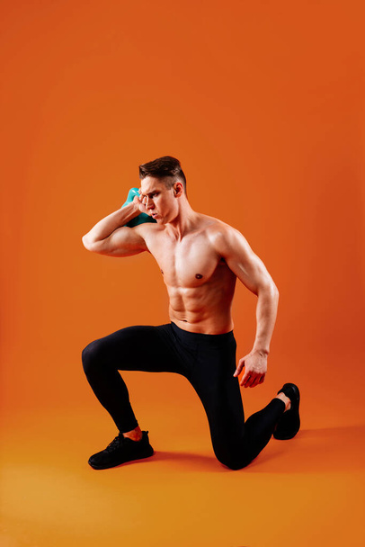 Athletic man with fit muscular body training in studio - Active man doing a workout, colorful lighting and background, concepts about fitness, sport and health lifestyle - Foto, afbeelding