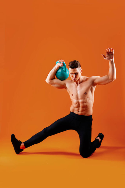 Athletic man with fit muscular body training in studio - Active man doing a workout, colorful lighting and background, concepts about fitness, sport and health lifestyle - Fotó, kép