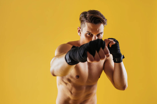 Athletic man with fit muscular body training in studio - Active man doing a workout, colorful lighting and background, concepts about fitness, sport and health lifestyle - Photo, Image