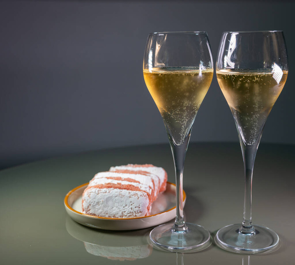 Glasses of sparkling white wine champagne or cava with bubbles and sweet dessert Reims rose biscuits on background, Reims, France - Foto, Imagem