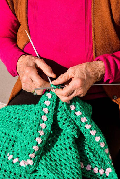 Close-up image of an old woman with knitting needles and wool - Fotoğraf, Görsel