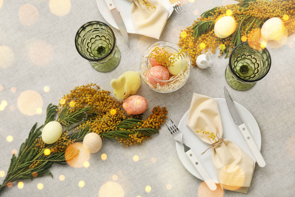 Stylish table setting for Easter dinner with mimosa flowers, top view - Foto, Bild