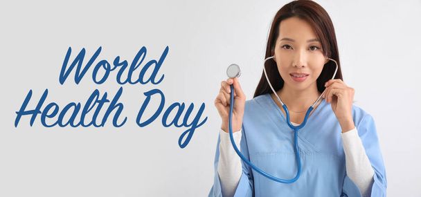 Médecin asiatique avec stéthoscope sur fond blanc. Journée mondiale de la santé - Photo, image