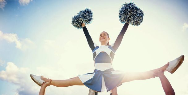 Cheerleader woman, sky and sports performance with smile and energy to celebrate outdoor. Cheerleading person dance with team support, motivation and hands for training, workout or competition. - Фото, зображення