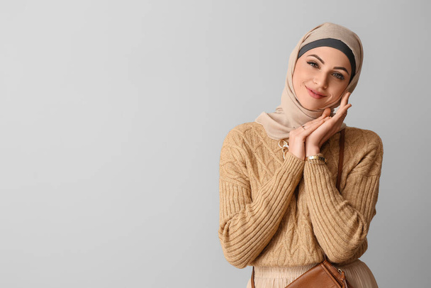 Tyylikäs musliminainen beige hijabissa kevyellä taustalla - Valokuva, kuva