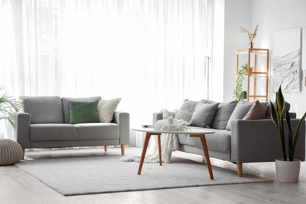 Interior de la moderna sala de estar con sofás, mesa y obras de arte creativo - Foto, Imagen