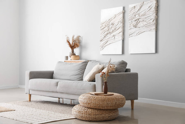 Belső tér modern nappali kanapéval, rattan poufs és kreatív alkotások - Fotó, kép