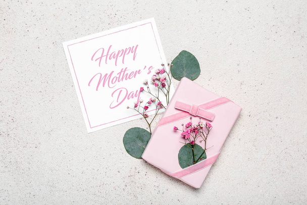 Card with text HAPPY MOTHER'S DAY and beautiful gift box on light background - Фото, изображение