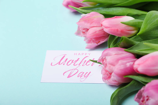 Cartão de saudação com texto HAPPY MÃE 'S DAY e belas flores de tulipa em fundo turquesa - Foto, Imagem