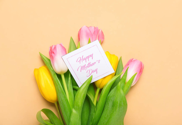 Κάρτα με κείμενο HAPPY MOTHER 'S DAY και όμορφα λουλούδια τουλίπας στο φόντο χρώμα - Φωτογραφία, εικόνα