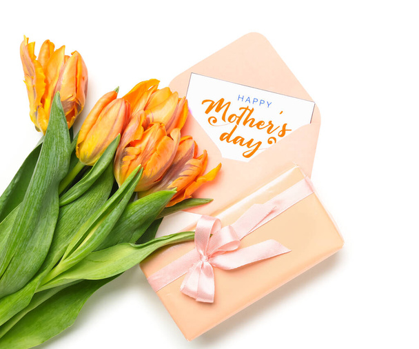Composición con tarjeta de felicitación, caja de regalo y flores de tulipán sobre fondo blanco. Celebración del Día de la Madre - Foto, Imagen
