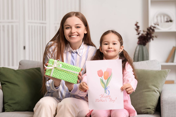 Linda niña con tarjeta de felicitación para el Día de la Madre y su madre en casa - Foto, imagen