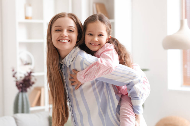 Cute little girl with her mom at home on Mother's Day - Photo, Image