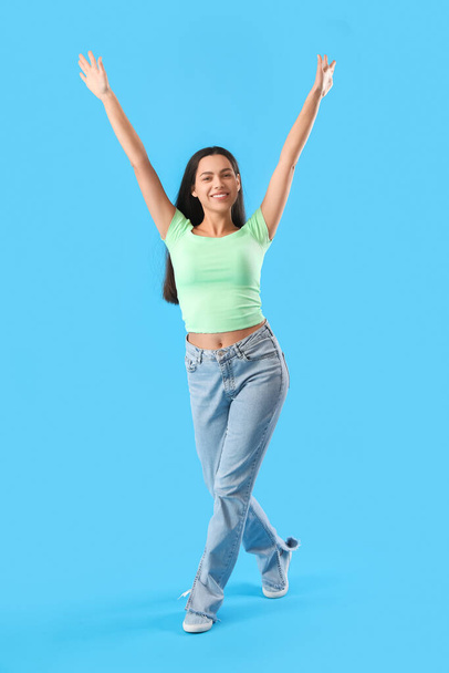Happy young woman on blue background - Zdjęcie, obraz