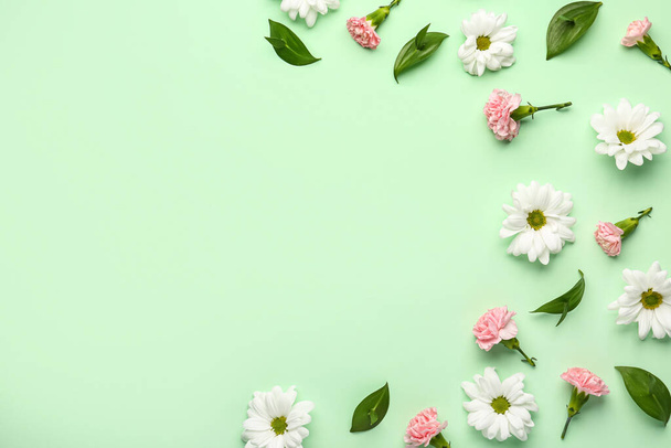 Composition with plant leaves, chamomile and carnation flowers on color background - Photo, image
