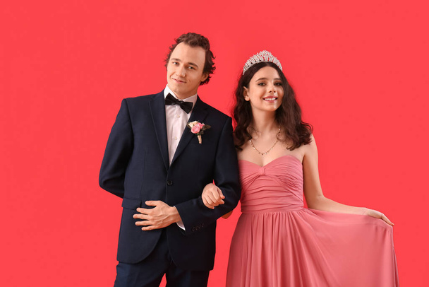 Beautiful couple dressed for prom on red background - Φωτογραφία, εικόνα