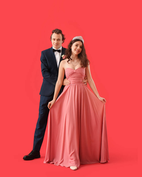 Beautiful couple dressed for prom on red background - Fotografie, Obrázek
