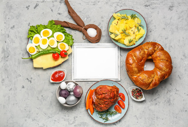 Композиция с пустой рамкой и вкусными блюдами для пасхального ужина на гранж-фоне - Фото, изображение