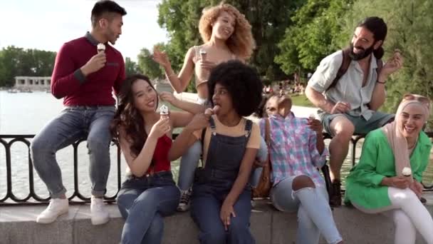 Group of multiracial friends eating an ice cream. Millennial people sightseeing in Madrid, Spain. - Footage, Video