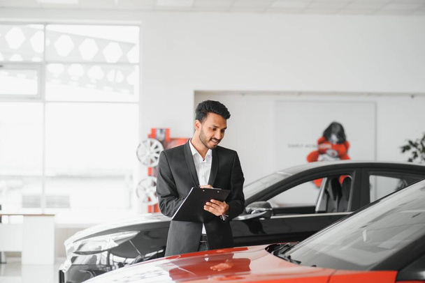 Successful indian businessman in a car dealership - sale of vehicles to customers - Foto, Imagen