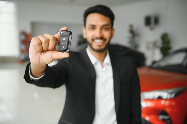 Close-up portret gelukkig, glimlachend, jongeman, koper tonen sleutels van zijn nieuwe auto. - Foto, afbeelding