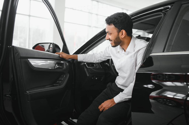 Young man sitting inside new car. Smiling. - Foto, immagini