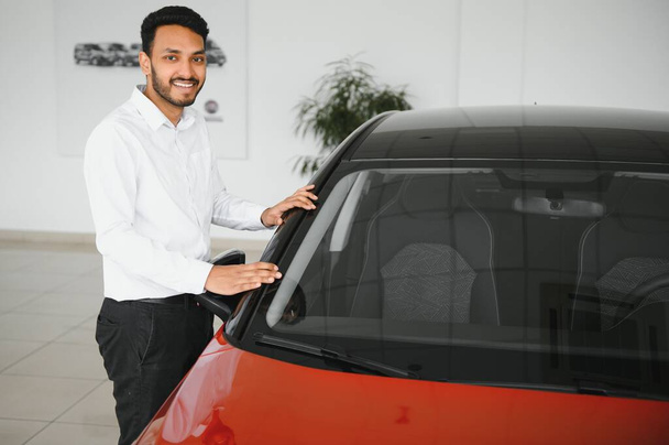 happy indian man buy new biodiesel eco automobile in lux showroom - 写真・画像