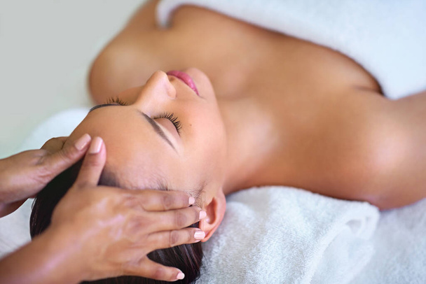 Massage du corps et de l'esprit. une jeune femme recevant un massage de la tête dans un spa - Photo, image
