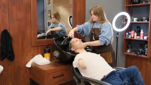 Перукарня миє волосся чоловіка з обмеженими можливостями в салоні краси
 - Кадри, відео