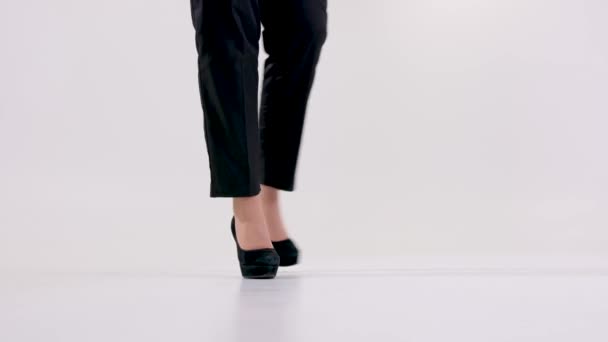 samice nohy na vysokých podpatcích boty v bílém studiu ležérně chůze svobodně žena klidný život spokojenost podnikatelka šéf prostor pro text nepoznatelný lidé černé kalhoty vysoké podrážky - Záběry, video