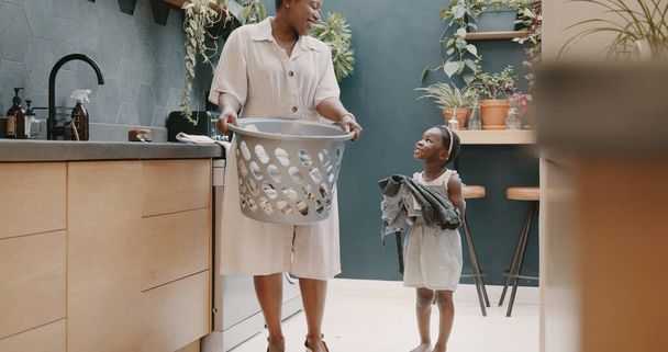 Lavandería, madre e hijo ayudando con el plegado de la ropa juntos en una casa. Chica feliz, emocionada y joven dando ayuda a su mamá mientras limpia la ropa de una lavadora en su casa. - Foto, Imagen