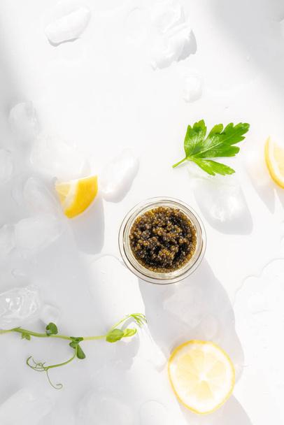 Aperitivos de deliciosas iguarias, esturjão natural caviar preto, fatia de limão, salsa em cubo de gelo. Foco seletivo - Foto, Imagem