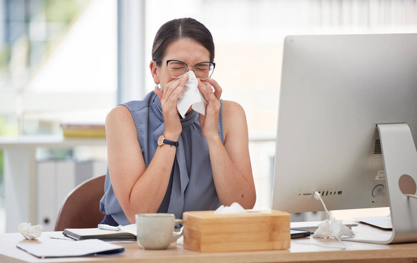 Άρρωστος, υπολογιστής και φυσώντας μύτη με γυναίκα στο γραφείο για τον ιό, την ασθένεια και τα συμπτώματα αλλεργίας. Φτάρνισμα, ασθένεια και ιστός με εργαζόμενο που πάσχει από λοίμωξη στο γραφείο για γρίπη, πυρετό και κρύο. - Φωτογραφία, εικόνα