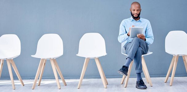 Waiting room, tablet and black man sitting at job opportunity, career application or Human Resources interview. Professional person or worker search online website for hr recruitment or hiring email. - Foto, Bild