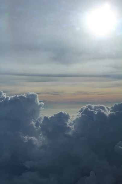 Fondo de paisaje nuboso. Vista desde arriba, desde la ventana de un avión. Cielo colorido con el sol. - Foto, Imagen