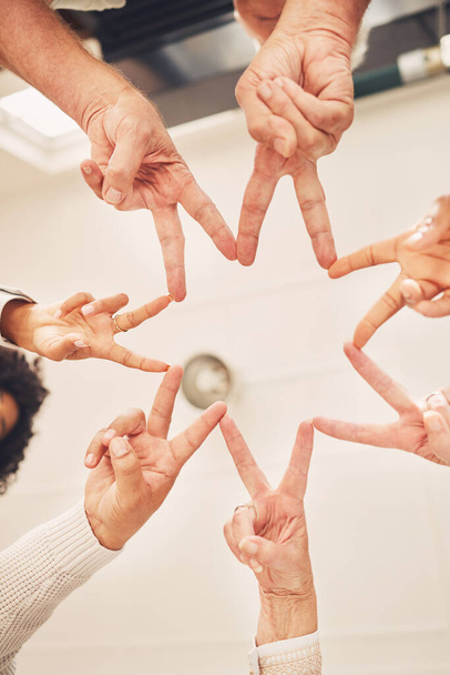 Business people solidarity, together and peace hands sign for company commitment, job unity or collaboration. Group star, mission teamwork and below view of design team building for community support. - 写真・画像