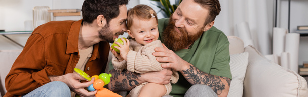 Positieve hetzelfde geslacht ouders op zoek naar baby dochter met appel thuis, banner  - Foto, afbeelding