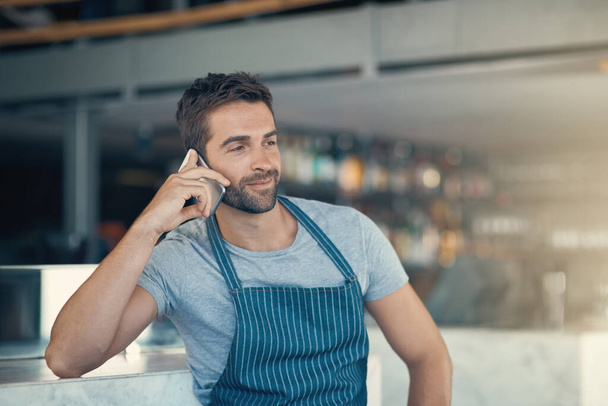 Snímek mladého muže pomocí mobilního telefonu při práci v kavárně. - Fotografie, Obrázek