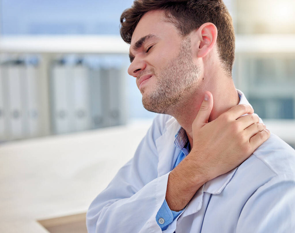 Tired, stress and man or doctor neck pain in office overworked, burnout or tension for healthcare problem. Medical professional worker, frustrated person or nurse with muscle injury at desk. - Photo, Image