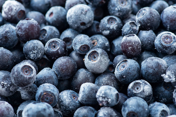 Macro photo of frozen blueberry. Storing berries for cold season, saving blueberry in freezer - Foto, Imagen