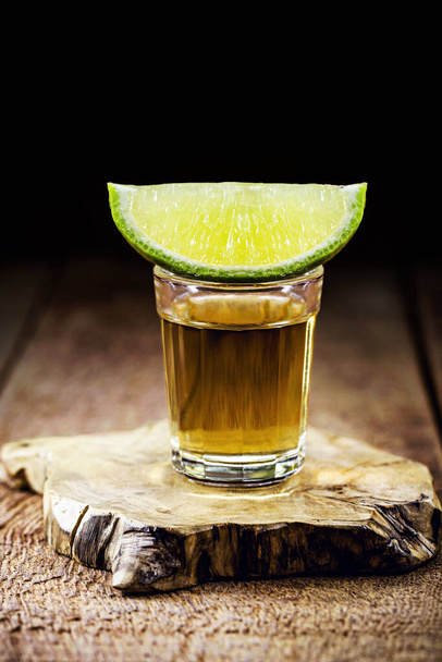 cachaca, brazilian drink with sugar, lemon and ice, typical distilled drink from brazil, on wooden bar background - Photo, Image