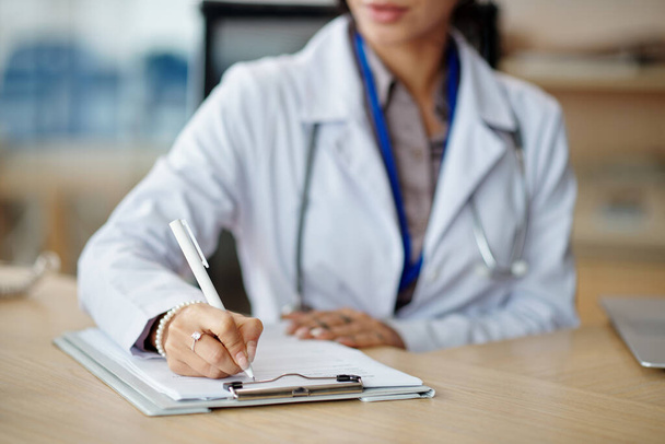 Cropped image of general practitioner filling form with personal data of patient - Photo, Image