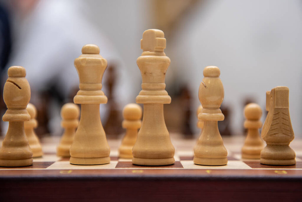 Schaakbord, foto van schaken en klok op tafel, strategisch schaakspel op houten bord - Foto, afbeelding