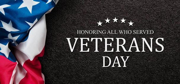Closeup of American flag with Text Veterans Day Honoring All Who Served on black textured background. American holiday banner. - Photo, Image