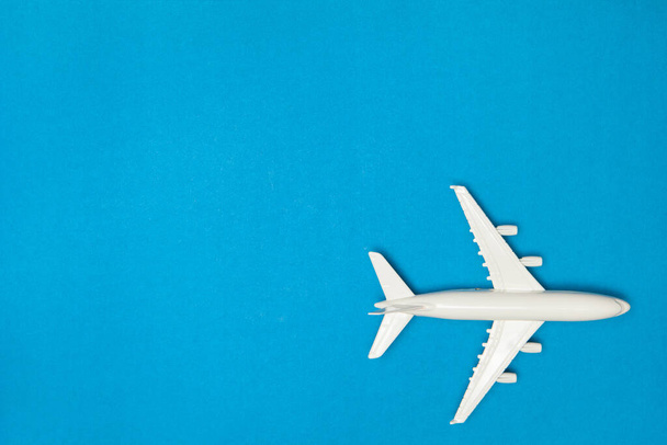 Airplane model. White plane on blue background. Travel vacation concept. Summer background. Flat lay, top view, copy space. - Fotoğraf, Görsel